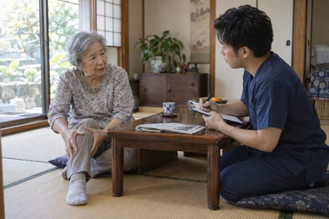 ご自宅で施術者が膝の痛みについて話を聞くカウンセリングの様子(イメージ写真)